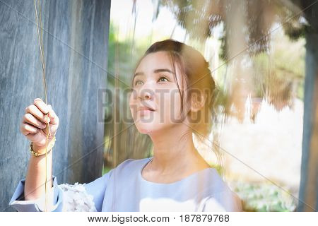 portrait of confident flirting woman with sexy looking creep plant in hands under sunlight