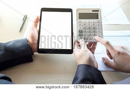 Businessman analysis on calculator new plan financial graph data with business colleagues using digital tablet for estimation at the office invesment concept.