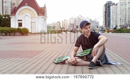 Young man with a skateboard on the street of a big city