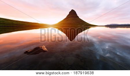 Colorful sunrise on Kirkjufellsfoss waterfall. Amazing morning scene near Kirkjufell volkano, Iceland, Europe.
