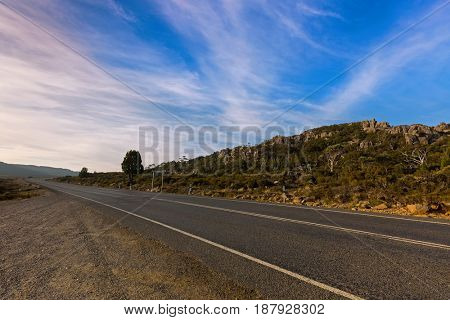 Asphalt Highland Lakes Road at Pine Lake area, Central Plateau in evening. Autumn in Tasmania, Australia
