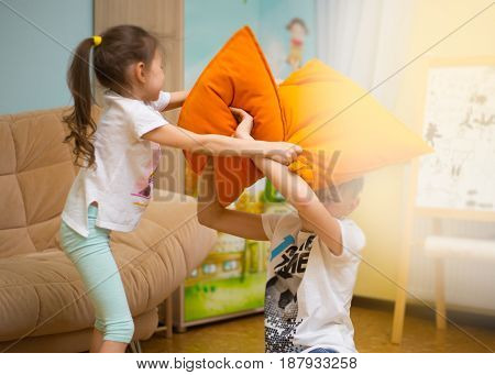 Happy family. Sister and brother are playing on the floor at home. Young boy and lovely girl having fun in children room.