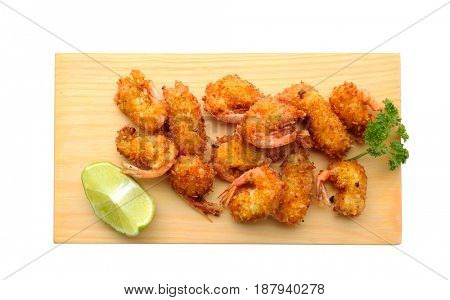 Wooden board with delicious coconut shrimps on white background