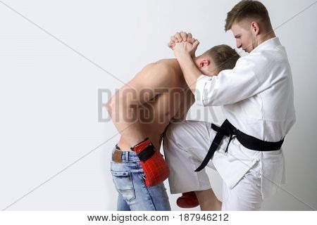 Karate Athlete In Kimono Kicking Knee At Boxer