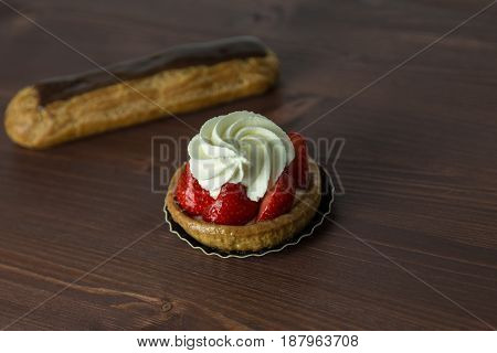 Delicious Strawberry Tarts With Chantilly Cream - Tartellete - And Chocolate Eclair On An Ipe Natura