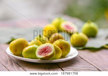 Ripe sweet figs, exotic tropical fruit on wooden table