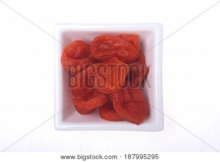 Delicious dried organic apricots on bowl isolated over white background