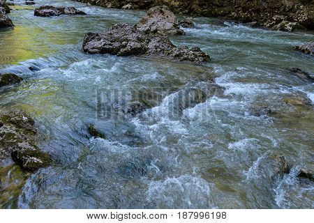 Mountain river flowing among the stone coasts