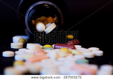 A Bottle Of Spilled Pills On Black Background.levitating Tablets. Tablets On A Dark Background That 