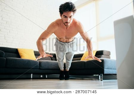 Adult Man Training Chest Muscles At Home Doing Explosive Push-ups