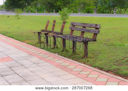 Old Chairs In The Park Beside The Walkway