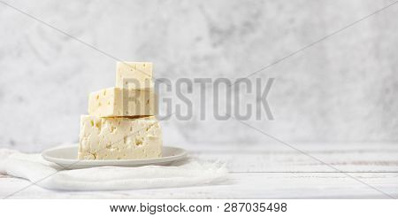 Sliced Feta Cheese On Light Background. High Key. With Copy Space.