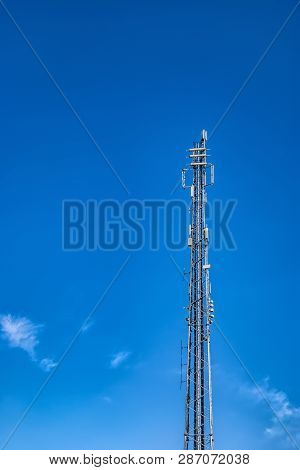 Communications Mast Set Against A Blue Summer Sky