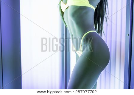 Close Up Of Slim Young Woman Perfect Body Standing In Solarium Getting Sun Tan