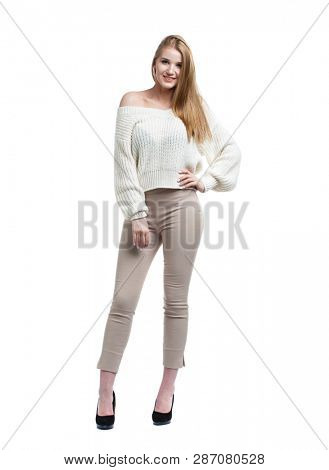 Sexy blonde woman in beige pants and white sweater, isolated on white background