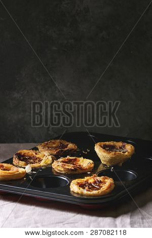 Traditional Portuguese Egg Tart Dessert Pasteis Pastel De Nata In Black Baking Tray Standing On Line