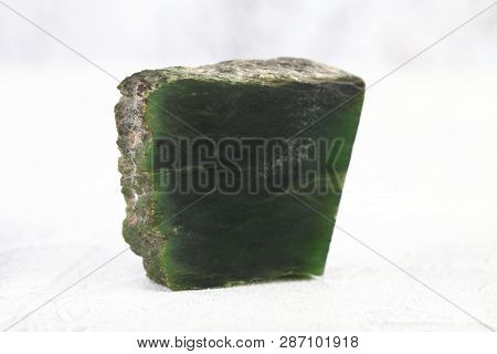 Texture Of Natural Green Stone Nephritis On White Cement Background. Semi Precious Stones.