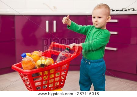 Cheerful Little Boy With Shopping Cart. Little Kid In Casual Wear Carrying Child Plastic Shopping Tr