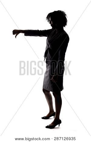 Silhouette Of A Black Businesswoman Gesturing Disapproval By Doing A Thumbs Down.  She Is Isolated O