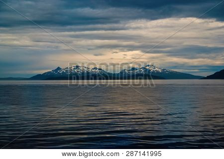 Sea In Hammerfest, Norway. Evening Seascape With Mountain Coast Under Cloudy Sky. Sea Travelling. Ad