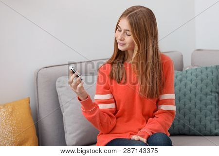 Teen Girl Holding Digital Glucometer At Home. Diabetes Control