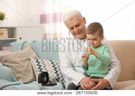 Doctor And Little Patient With Digital Glucose Meter At Home. Diabetes Control