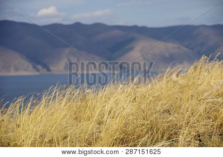 Yellow Dry Grass. Lake Sevan And Mountain Range At Background. Near Sevanavank (sevan Monastery) In