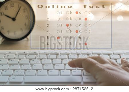 Dry Hand Of Adult Student Is Using Mouse And White Keyboard On Wood Table To Do Test Examination Wit