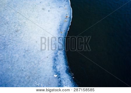 Spring Is Coming. Weather Change Concept. Ice Edge And Water Surface Close Up