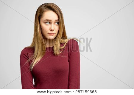Unhappy American Student Feeling Uncomfortable And Ashamed, Looking To Left With Sad Expression Whil