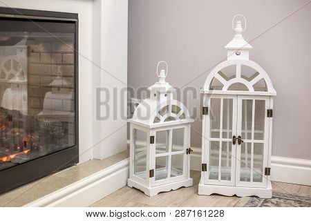 White Decorative Wooden Latern Lights In Expensive Interior Near Fireplace