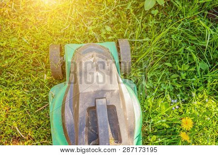 Lawn Mower Cutting Green Grass In Backyard In Sunny Day. Gardening Country Lifestyle Background. Bea
