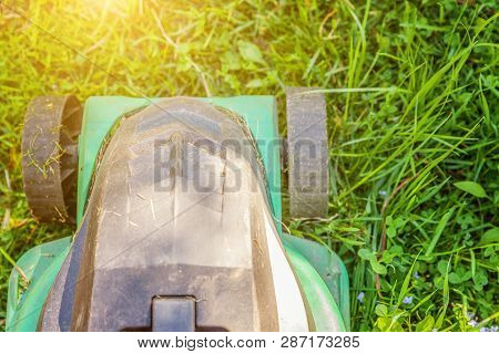 Lawn Mower Cutting Green Grass In Backyard In Sunny Day. Gardening Country Lifestyle Background. Bea