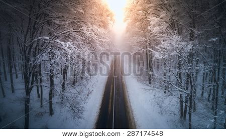 Aerial View Of Snowy Forest With A Road At Sunset. Captured From Above With A Drone. Carpathians, Ro