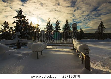 A Terrace Under A Heavy Snow With Forest Behind In Direct Afternoon Sun On Partly Cloudy Day In Nort