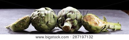 Artichokes On Rustic Background. Fresh Organic Artichoke Flower Set