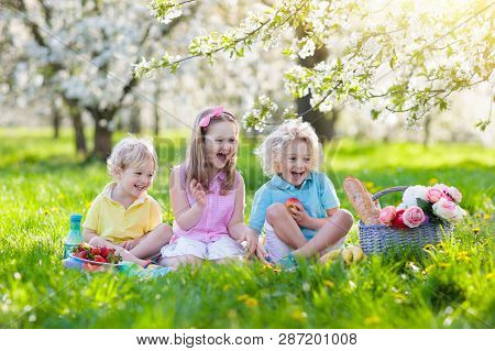 Family Picnic In Spring Park. Kids Eating Outdoors