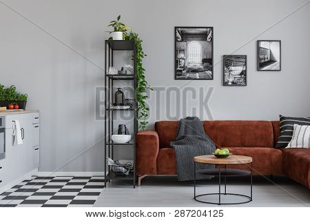 Round Coffee Table With Green Apples In The Bowl In Front Of Brown Velvet Sofa In Small Studio Apart