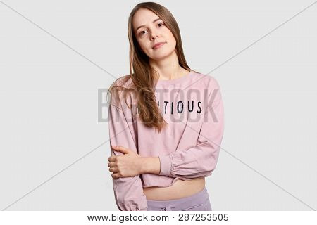 Half Length Shot Of Serius Contemplative European Woman Keeps Hands Partly Crossed Oves Chest, Drese