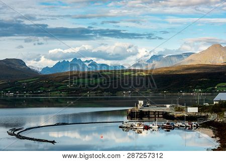 Small Fhishing Harbor By Mountains In Northern Norway