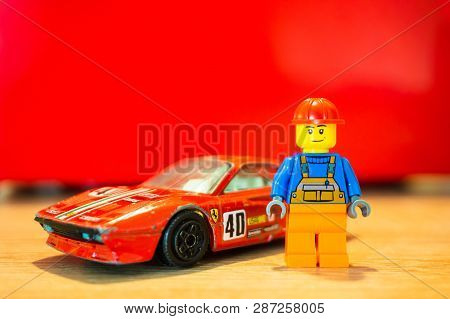 Poznan, Poland - February 15, 2019: Lego Construction Worker Figure Standing Next To His Parked Red 