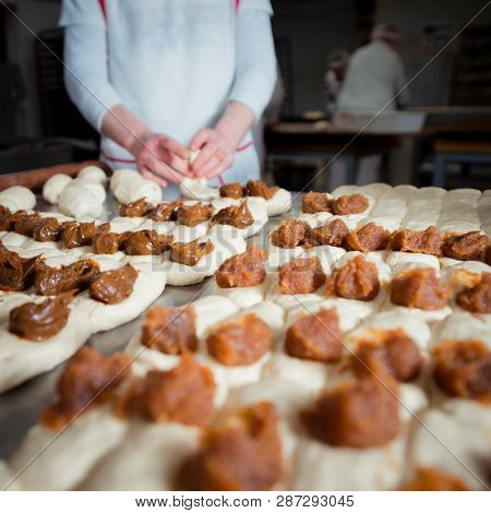 Baker Make Buns With Filling Of Jam And Condensed Milk  From Dough