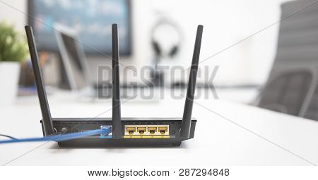 Modern Dual Band Wireless Router. Man Working In The Background. Fast And Wireless Internet Concept.