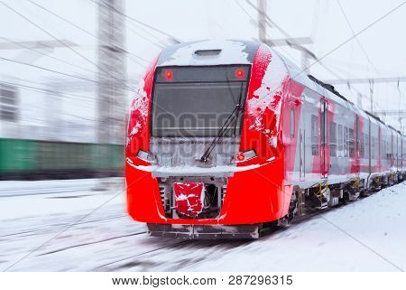 Ice-covered Electric Multiple Unit Train Rushes Along A Blurred Winter Railway Landscape