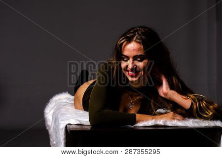 Beautiful Dancer. Girl Model. The Girl Sits In A Hat And Sits On A Table. Girl In A Beautiful Underw