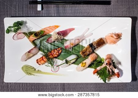 Mix Of Different Nigiri On A Bamboo Leaf Served With Daikon And Radish Julienne, Traditional Japanes