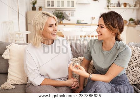 Indoor Image Of Attrctive Elegant Middle Aged Female Sitting On Couch At Home With Charming Young Br
