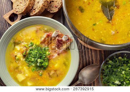 Delicious Yellow Split Peas Soup With Smoked Pork Ribs  On A Wooden Table. Top View