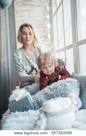 Mother With A Little Daughter. Family In Home Clothes.