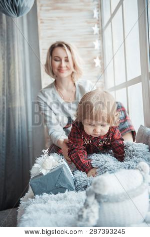 Mother With A Little Daughter. Family In Home Clothes.